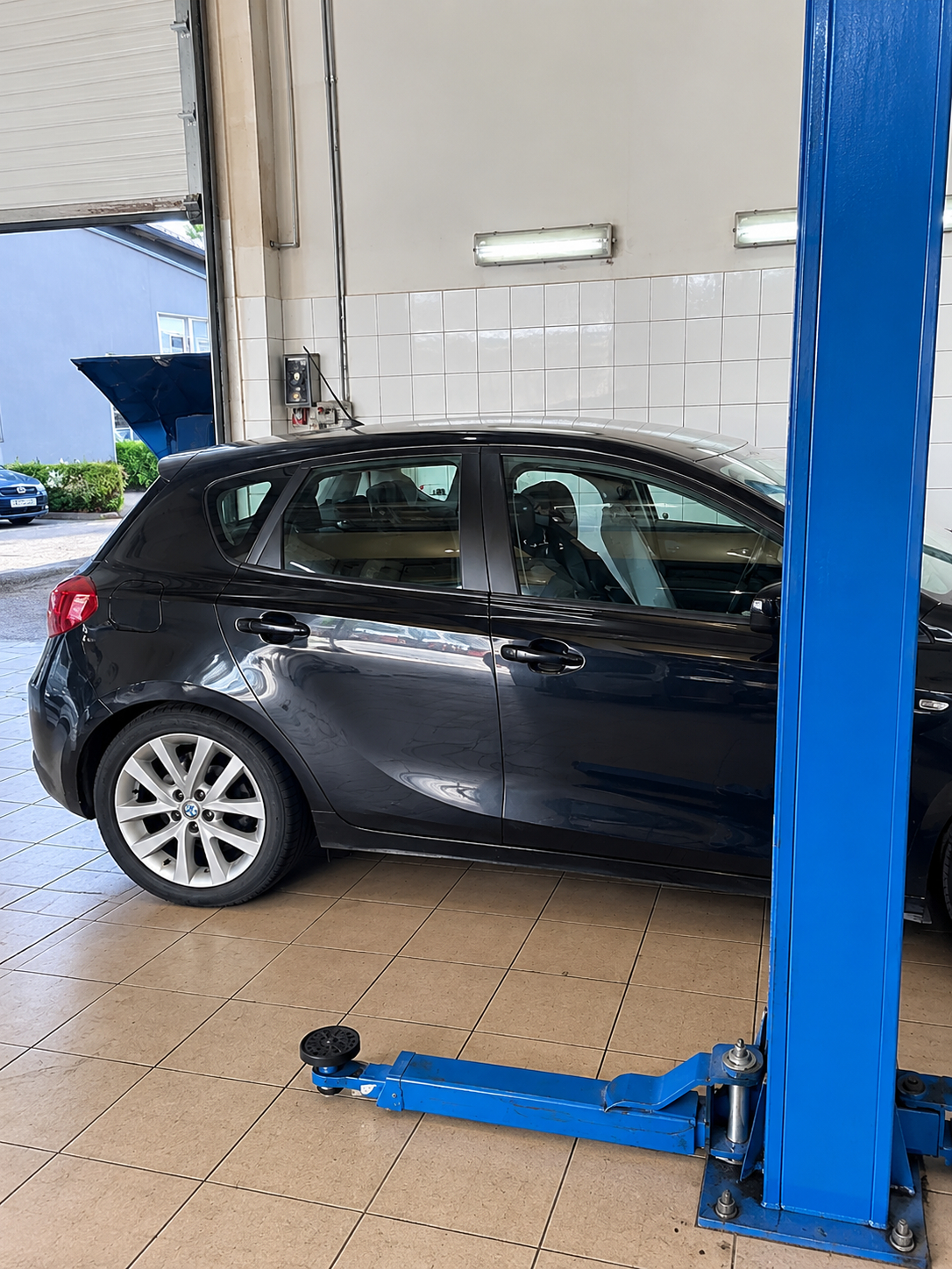 Samochód osobowy na podnośniku dwukolumnowym podczas przeglądu w warsztacie MotoTech