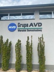 Budynek warsztatu Grupa MotoTech z szyldem przy ulicy Przykładowej w Nowogrodzie